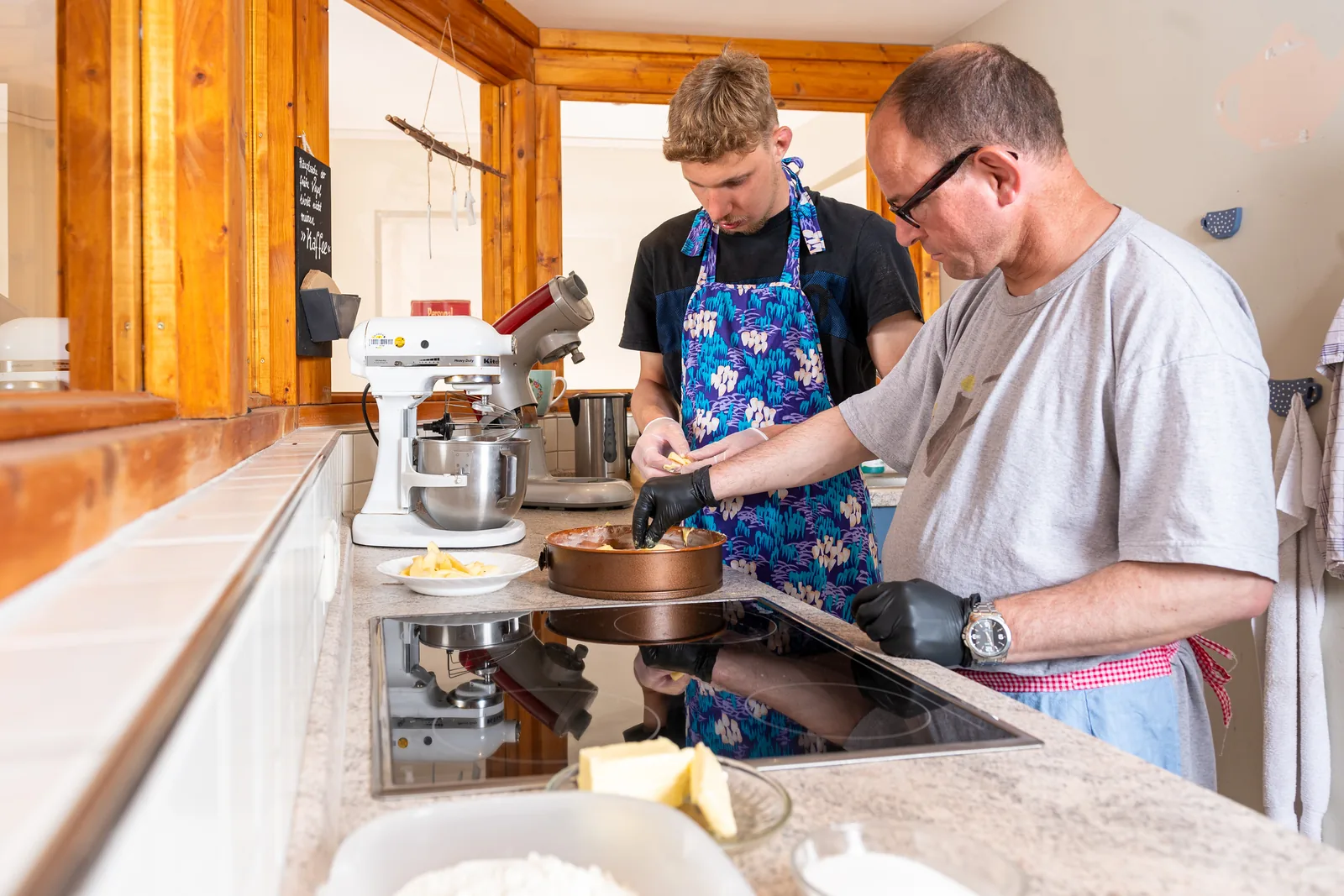 Bewohner und Betreuer backen gemeinsam einen Kuchen in der internen Tagesstruktur Mechau