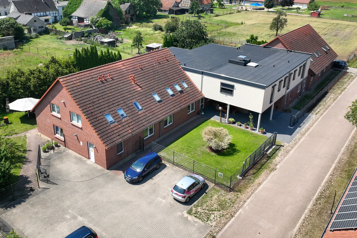 Luftbild von Haus Mechau in Arendsee OT Mechau, Backsteinhaus mit modernem Anbau und Parkplatz