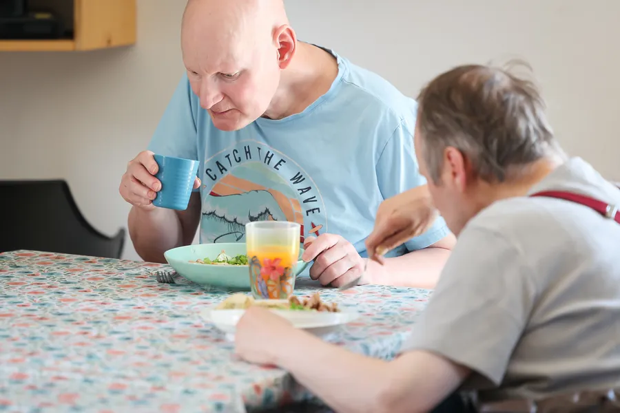 Zwei Bewohner beim gemeinsamen Essen am Tisch